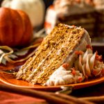 A slice of pumpkin layer cake on a plate with a fork.